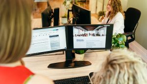 Personen achter computer met kennisbank op scherm